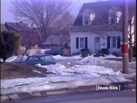 Winter suburban street scene featuring two men near a parked car and a yellow fire hydrant.