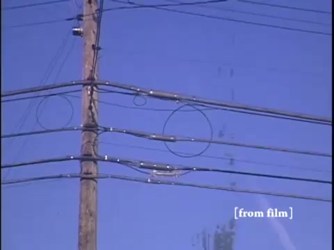 Intricate details of utility poles and wires above a winter suburban street.
