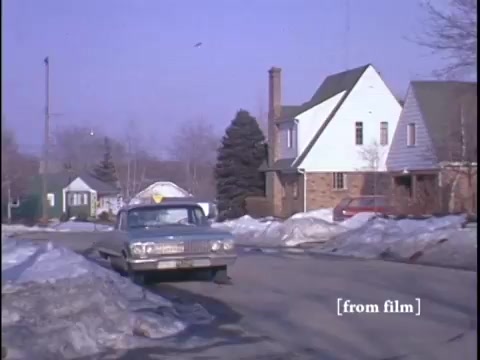 Low angle shot of residential homes and snow piled along the road.