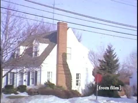 Modest home with a prominent chimney and power lines stretching across the sky.
